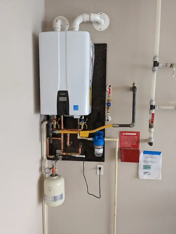 Professional plumber installing copper piping in a Plympton home